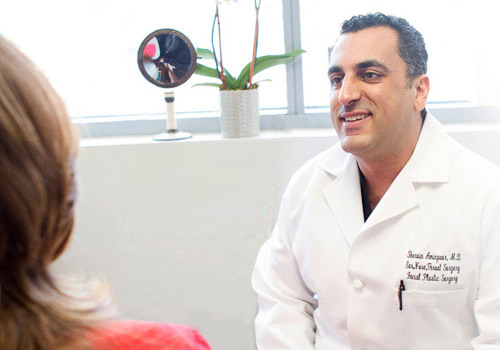 Dr. Aminpour happily speaking with patient