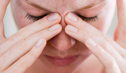 Woman pressing on her nose