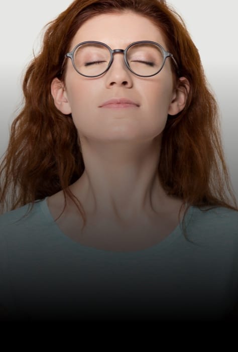 Woman wearing glasses happily breathing through nose