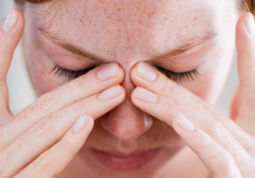 Woman rubbing nose