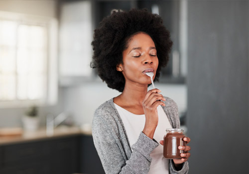 Woman eating peanut butter out of a jar