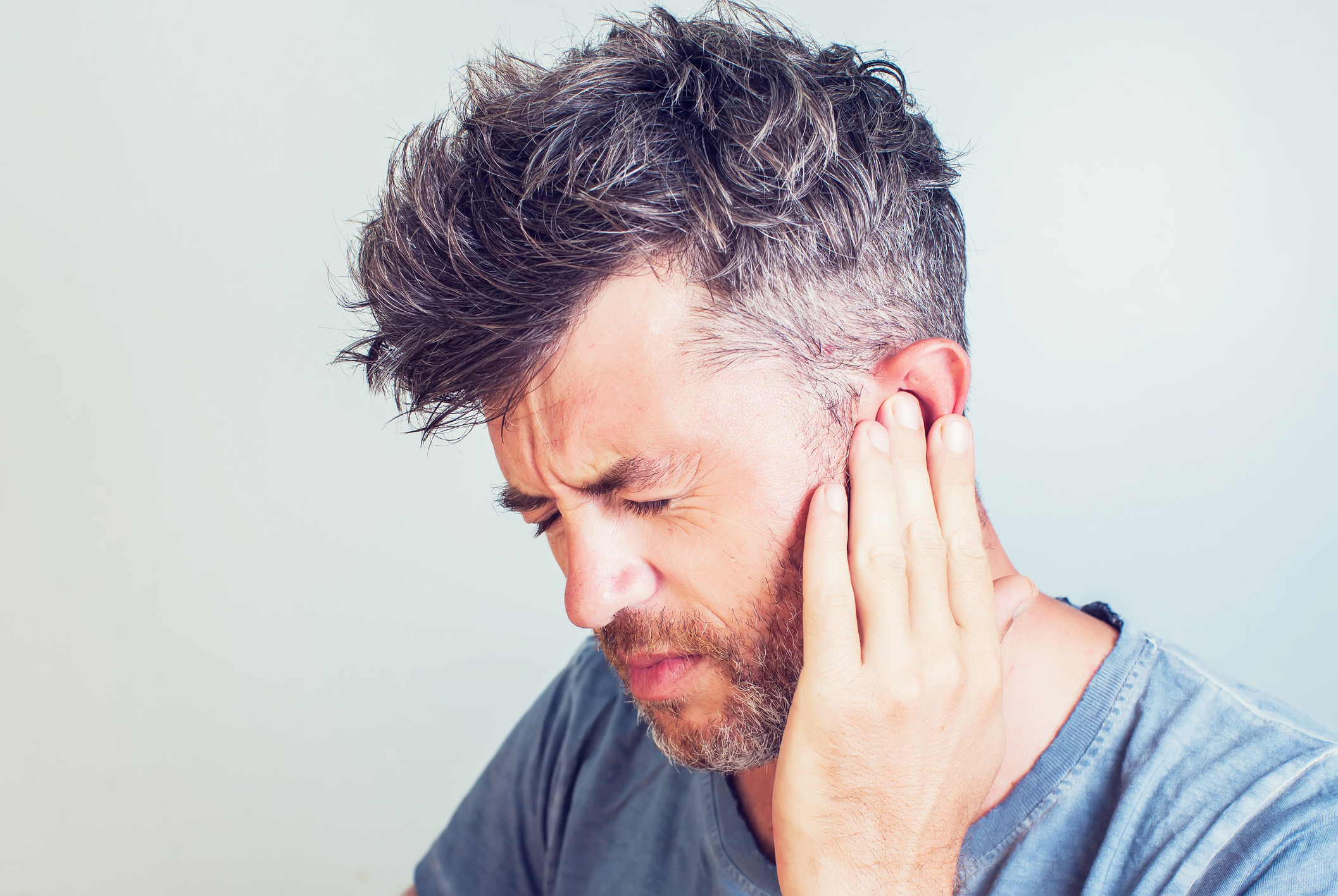 Man holding ear in pain